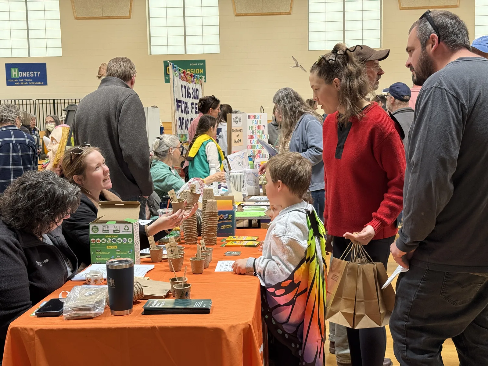 Festival visitors at an exhibitor table inside Harriet Beecher Stowe Elementary School during the 2026 Earth Day Festival in Brunswick