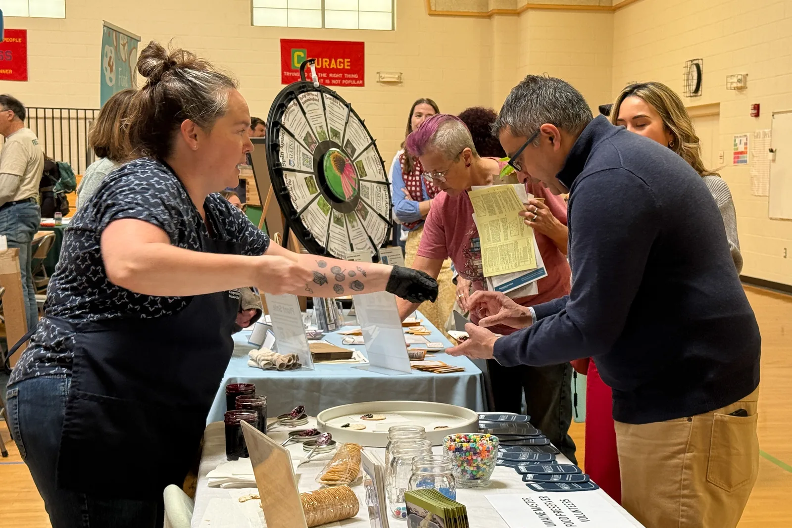Festival visitors sampling food from exhibitor tables in the gym
